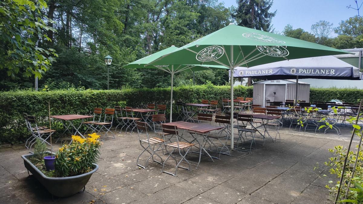 Sommerlicher Biergarten der Vereinsgaststätte TVM mit grünen Sonnenschirmen
