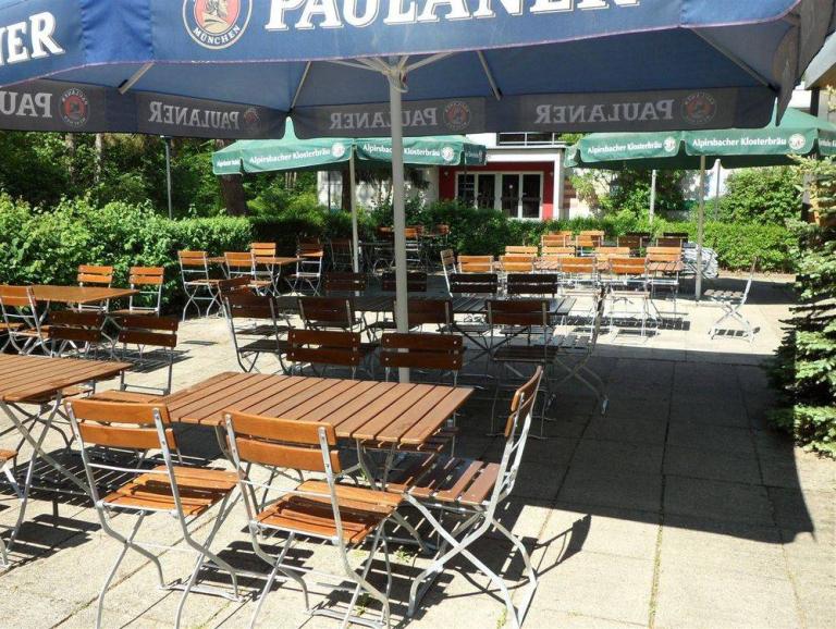 Terrasse der Vereinsgaststätte mit Bierbänken und Sonnenschirmen